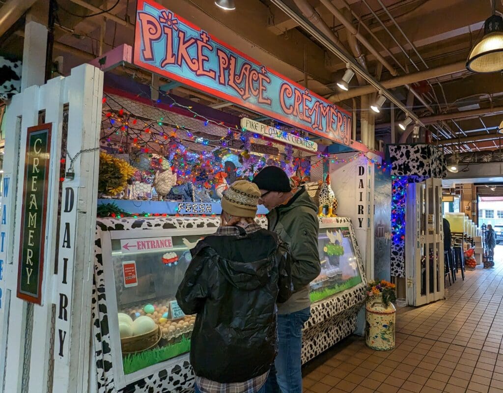 A couple standing in front of Pike Place Market Creamery at Pike Place Market in Seattle
