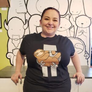 a person wearing a tshirt of a robot holding a sloth